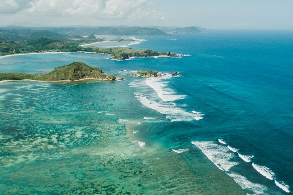 Aerial drone view of Lombok island coastline. Tanjung Aan bay. Amazing landscape with ocean waves