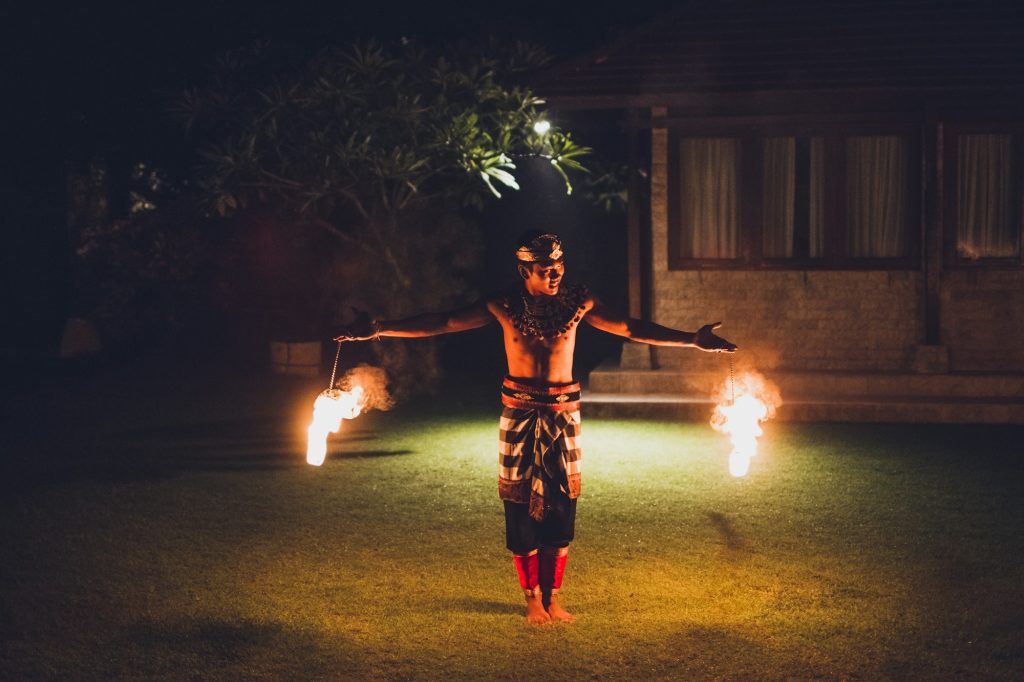 Balinese traditional dancing with fire show at evening beach party