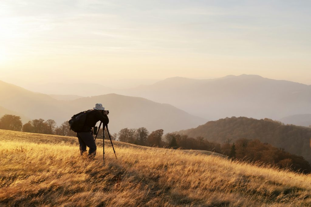 Photographer taking photo of autumn landscape